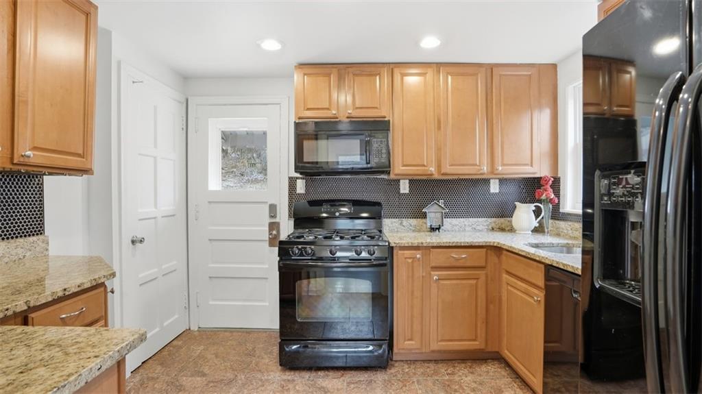 502 Weyman Road Pittsburgh, PA 15236 - Photo 11 of 39 a kitchen with stainless steel appliances granite countertop a stove a sink and a refrigerator