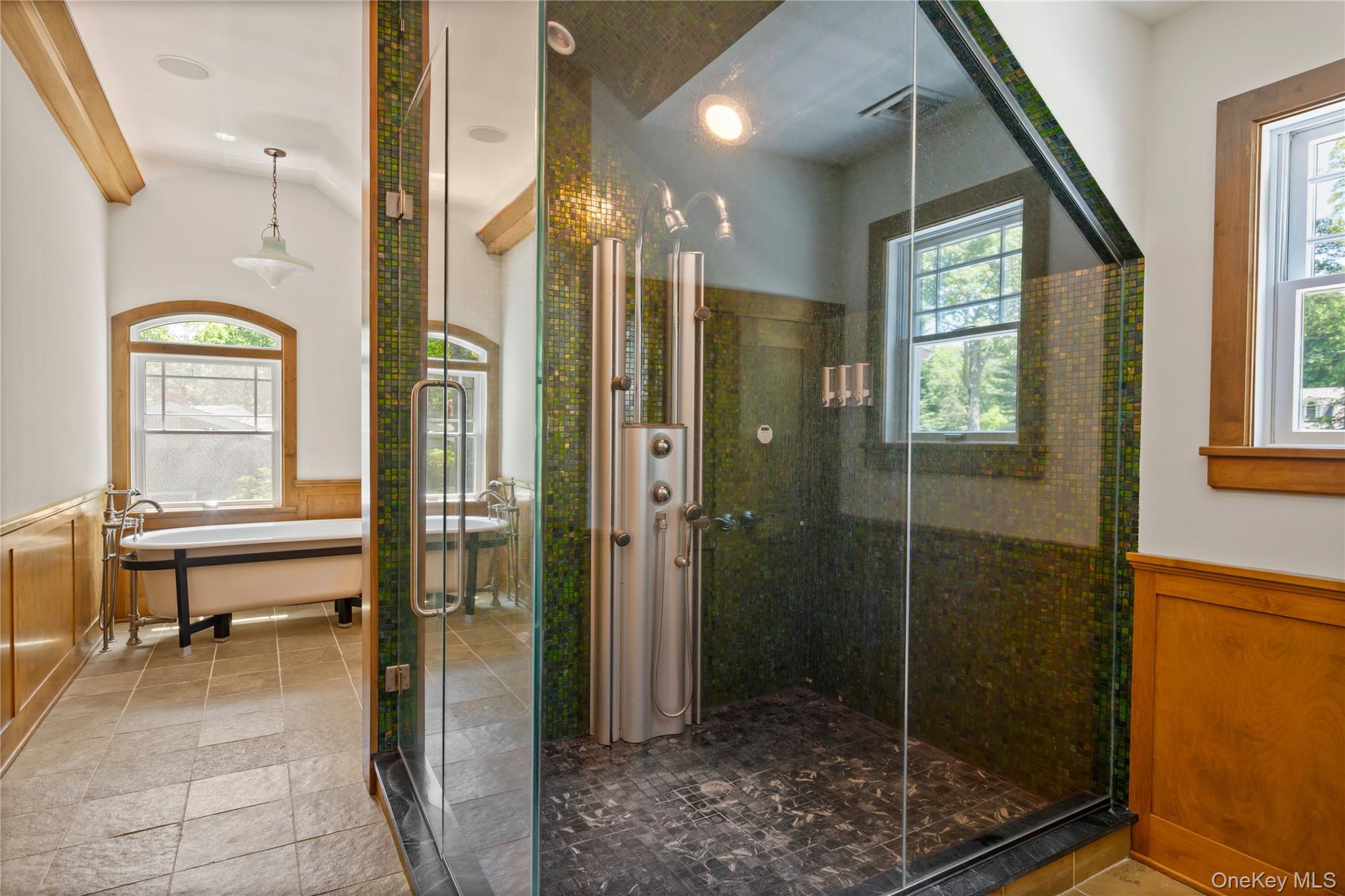 4745 North Bayview Road Southold, NY 11971 - Photo 14 of 31 Bathroom with a garden tub, lofted ceiling, a stall shower, a wainscoted wall, and stone tile flooring