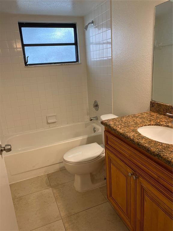 1520 Windorah Way, Unit E West Palm Beach, FL 33411 - Photo 3 of 12 a bathroom with a granite countertop toilet a sink and bathtub