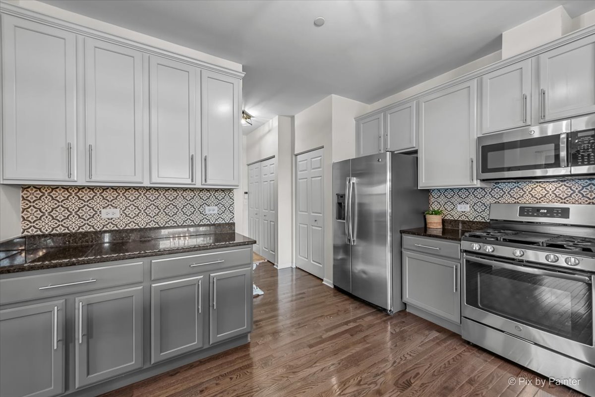 16207 West Switch Grass Road Lockport, IL 60441 - Photo 16 of 45 a kitchen with cabinets stainless steel appliances and wooden floor