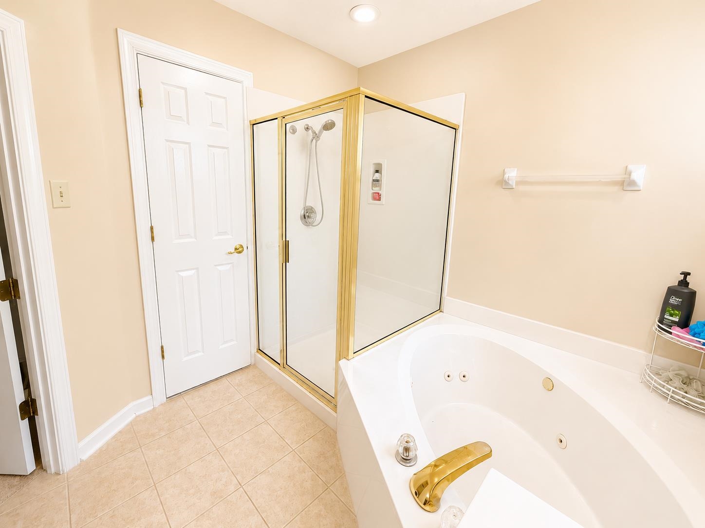 326 South Sanga Road Cordova, TN 38018 - Photo 18 of 32 Bathroom featuring a jetted soaking tub, a separate glass-enclosed shower with gold-toned framing, light-toned wall paint, and square floor tiling
