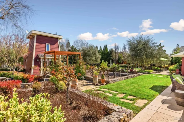 a view of a house with backyard water fountain and sitting area