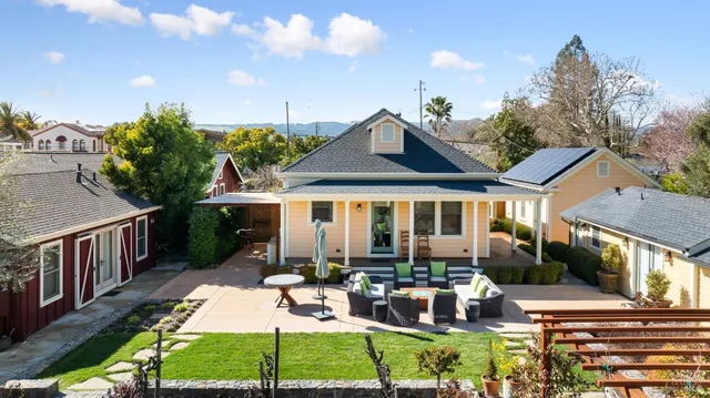 a living room with furniture kitchen view and a large window