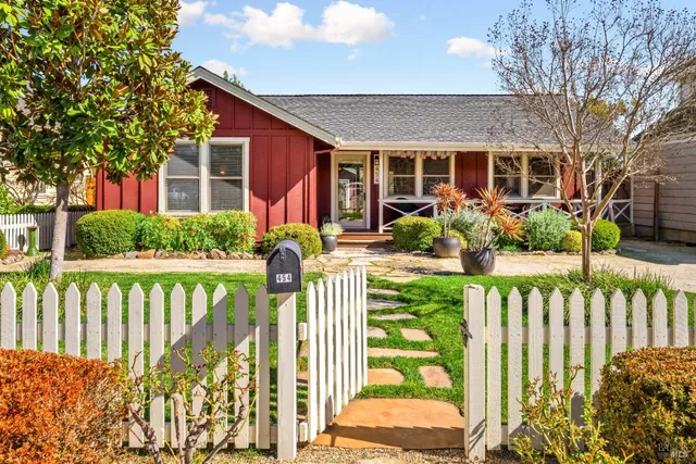a view of a house with backyard and a tree