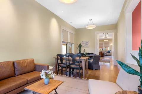 a living room with furniture a dining table and a chandelier