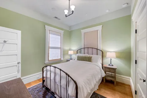 a bedroom with a large bed and a chandelier