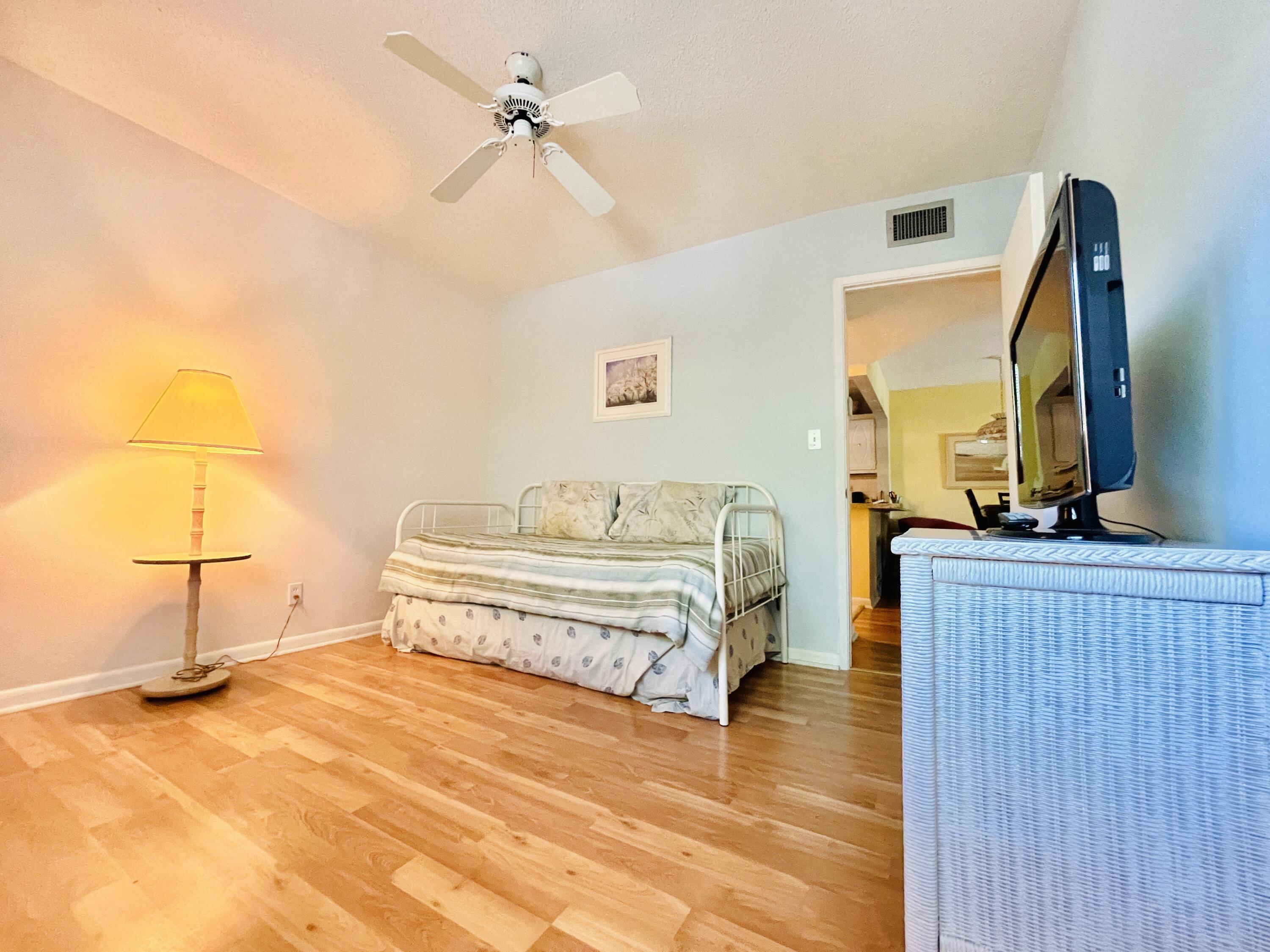 257 South Cypress Road, Unit 442 Pompano Beach, FL 33060 - Photo 15 of 37 a spacious bedroom with a bed and a mirror