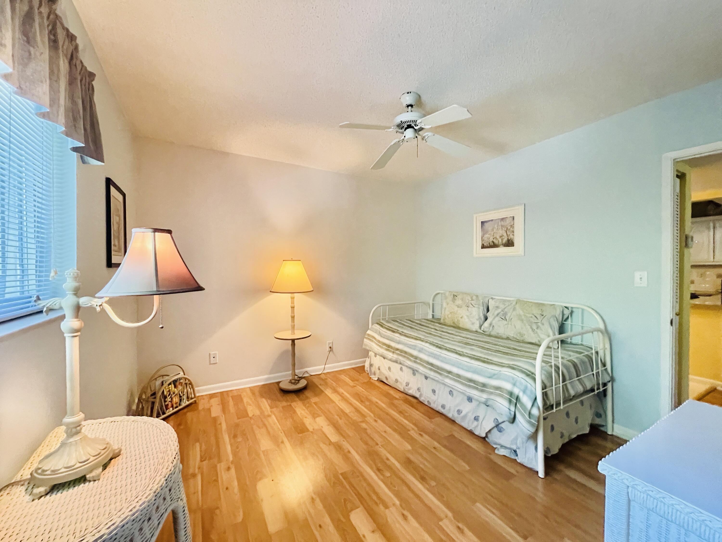 257 South Cypress Road, Unit 442 Pompano Beach, FL 33060 - Photo 16 of 37 a spacious bedroom with a bed and wooden floor