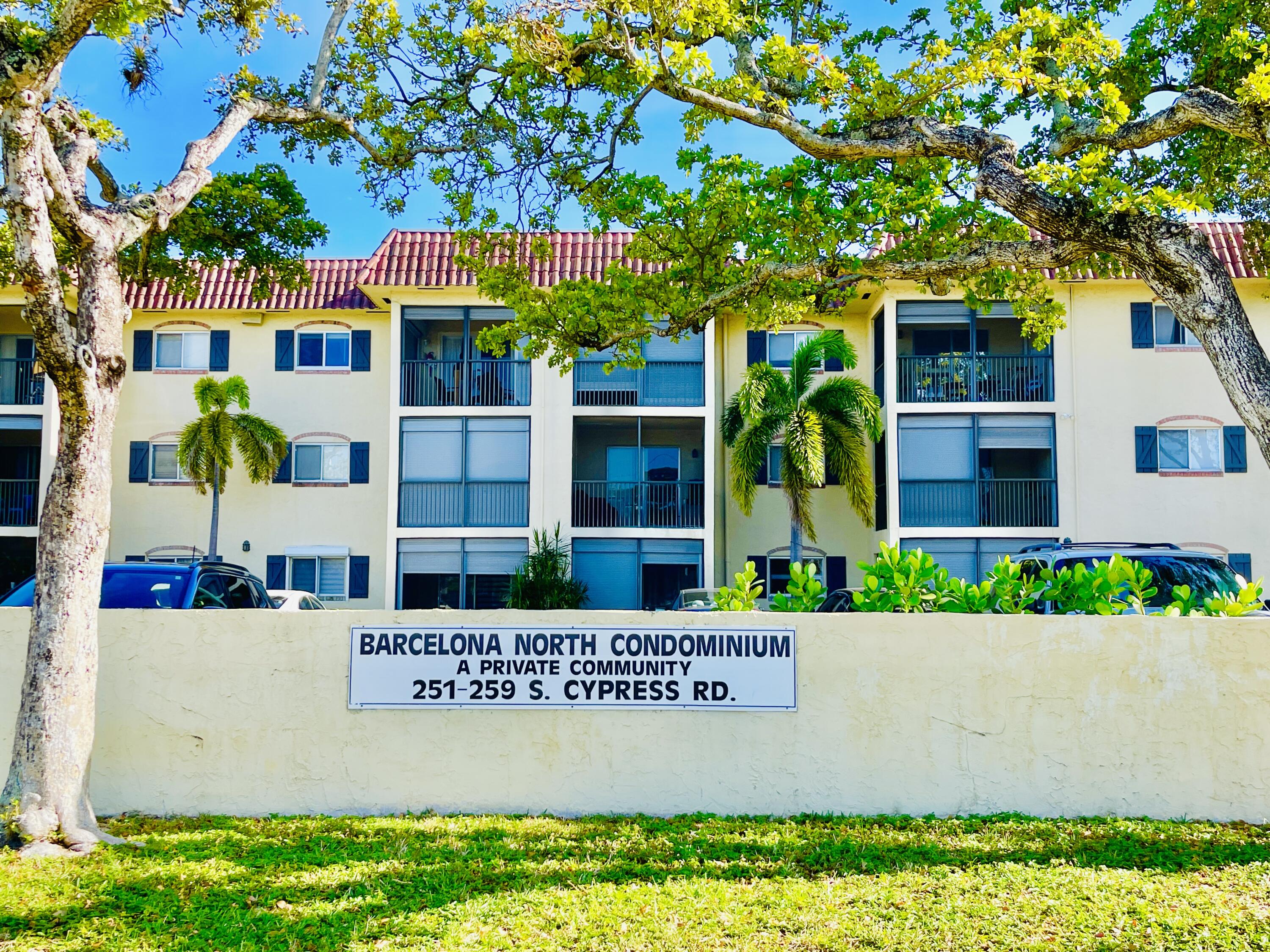 257 South Cypress Road, Unit 442 Pompano Beach, FL 33060 - Photo 3 of 37 a view of sign board with flower plants and wooden fence