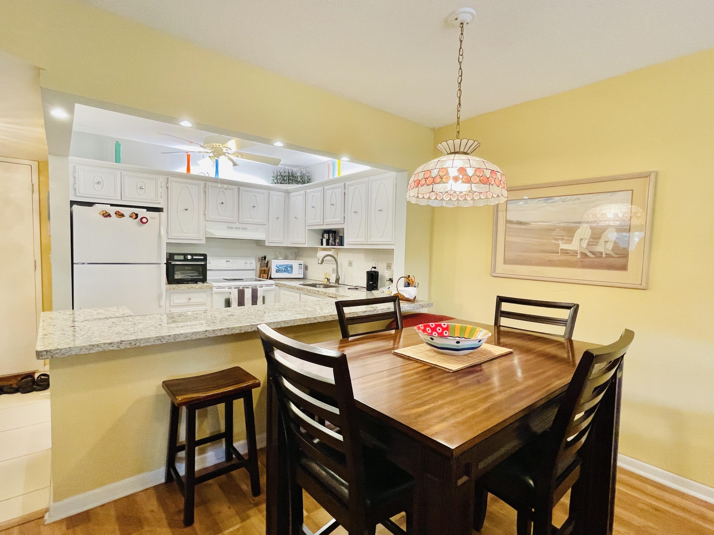 257 South Cypress Road, Unit 442 Pompano Beach, FL 33060 - Photo 6 of 37 a kitchen with kitchen island a dining table and chairs