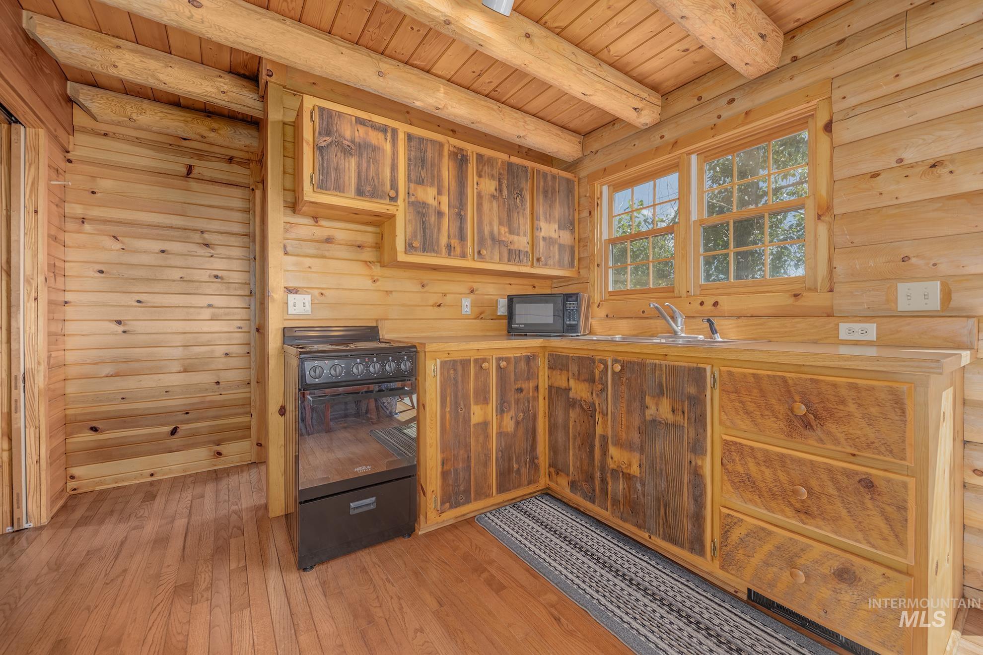 2150 Seid Creek Road Cambridge, ID 83610 - Photo 37 of 50 Wood-finish flooring complementing natural wood walls and exposed beam ceiling