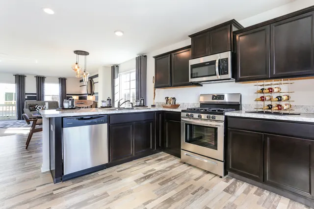 a kitchen with stainless steel appliances kitchen island granite countertop a stove and a microwave