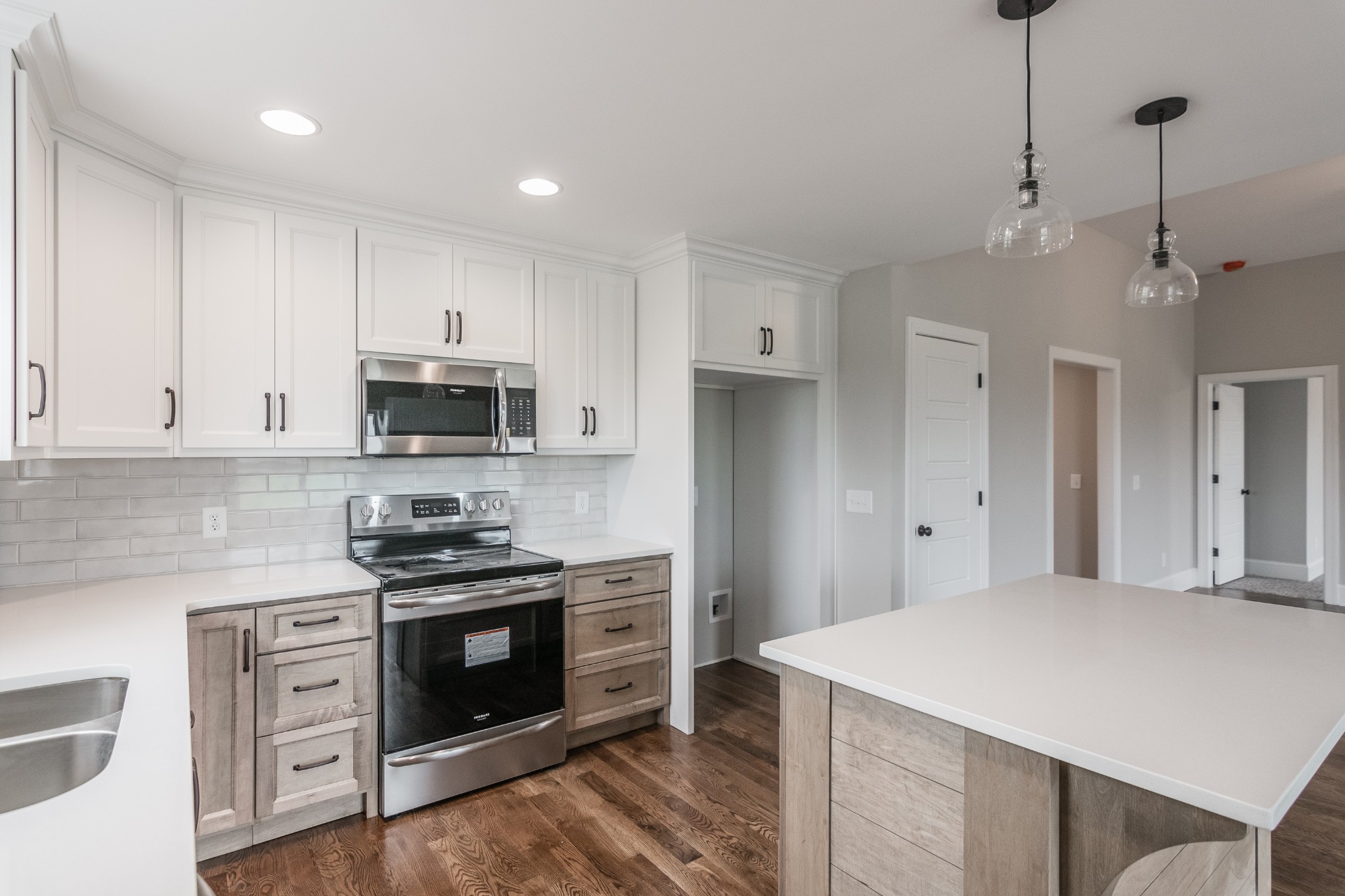 1227 Friendship Road Cross Plains, TN 37049 - Photo 20 of 28 a kitchen with stainless steel appliances white cabinets and a wooden floor