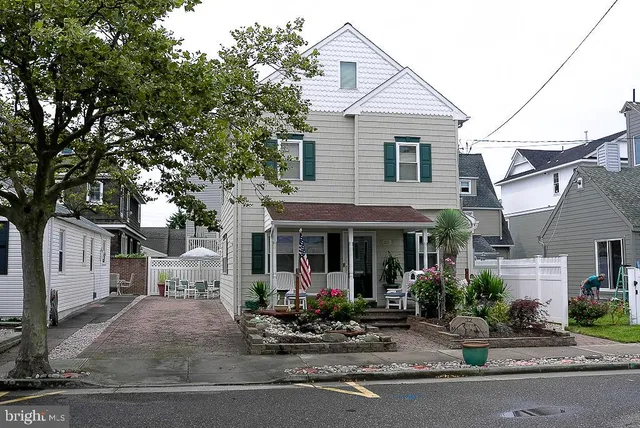 a view of a white house with large windows and a tree