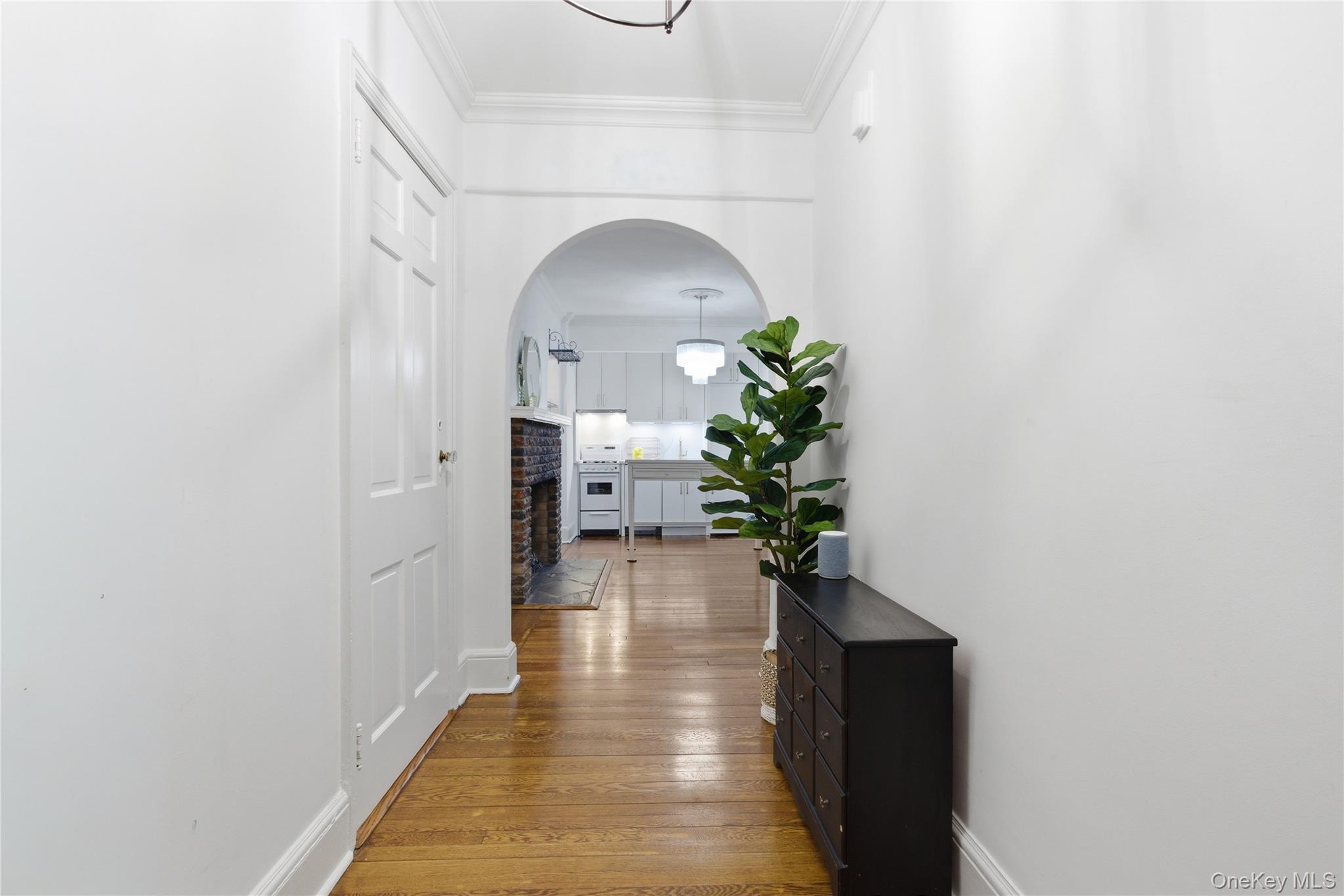 270 Bronxville Road, Unit B22 Bronxville, NY 10708 - Photo 5 of 23 Hall with arched walkways, light wood-type flooring, and ornamental molding