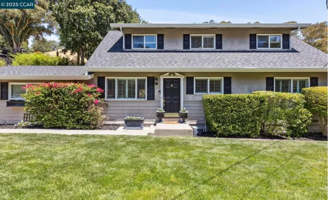 a view of a house with a yard and sitting area