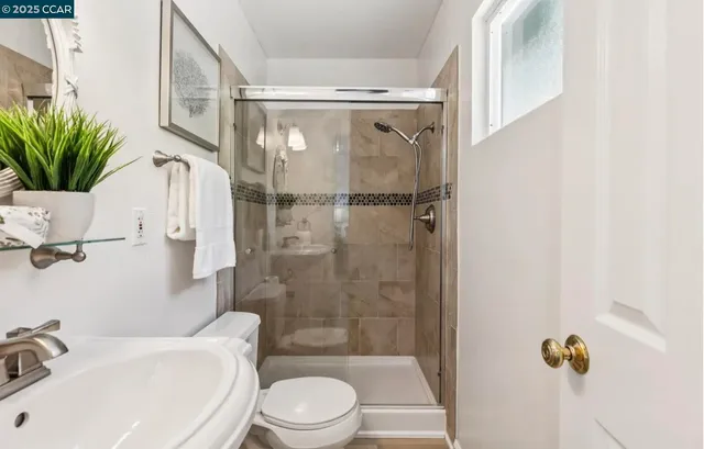 a bathroom with a shower a toilet and a sink