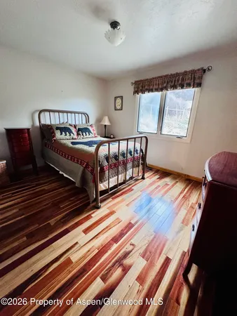 a bedroom with a bed and wooden floor