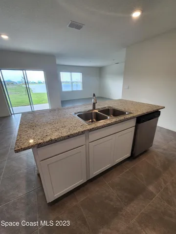 a kitchen with a granite countertop sink and window