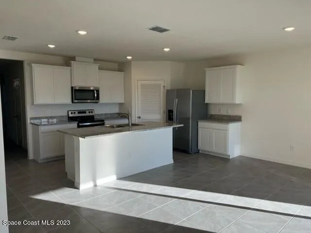 a kitchen with stainless steel appliances a refrigerator sink and microwave