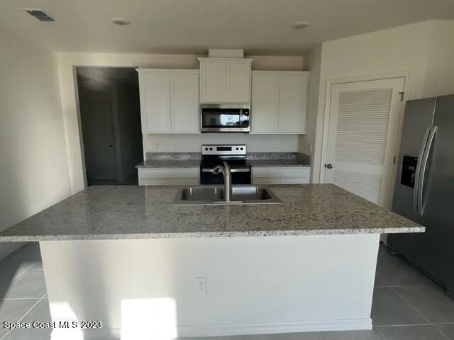 a kitchen with kitchen island a counter space and a refrigerator