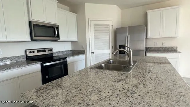 a kitchen with granite countertop a sink and a stove top oven