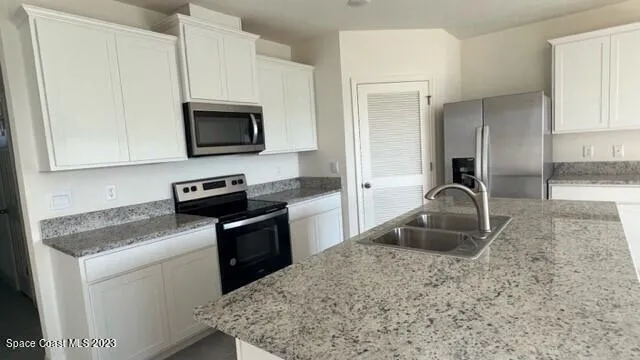 a kitchen with a sink stove and microwave