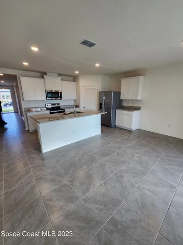 a kitchen with stainless steel appliances a refrigerator and a stove top oven