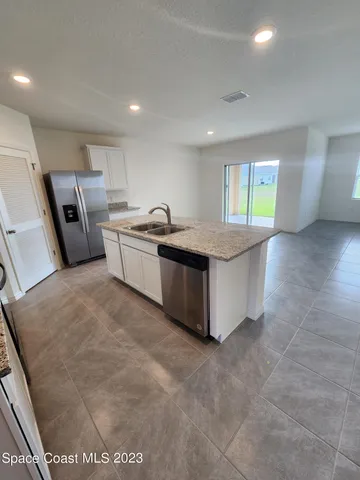 a kitchen with stainless steel appliances granite countertop a sink and a refrigerator