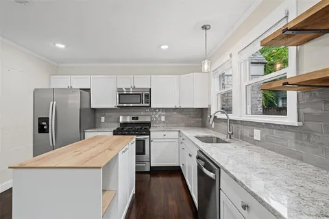 a kitchen with a sink a stove a refrigerator and cabinets