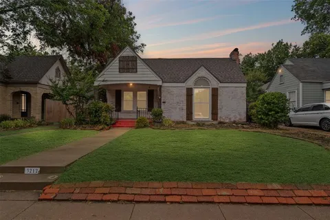 a front view of a house with a garden and plants