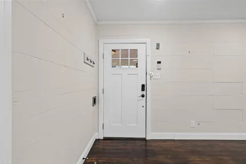 a view of a hallway with wooden floor and closet area