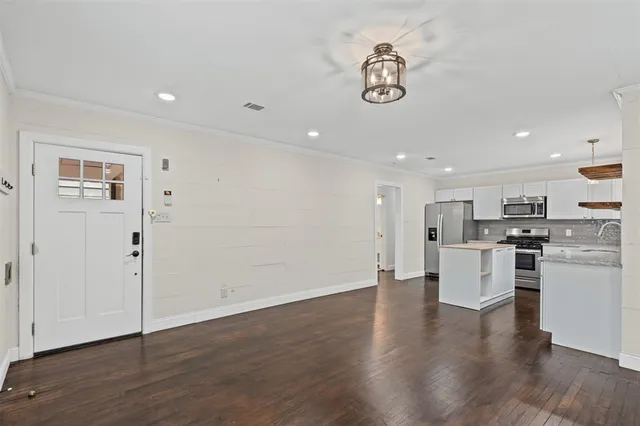 a view of kitchen with stainless steel appliances refrigerator stove and wooden floor