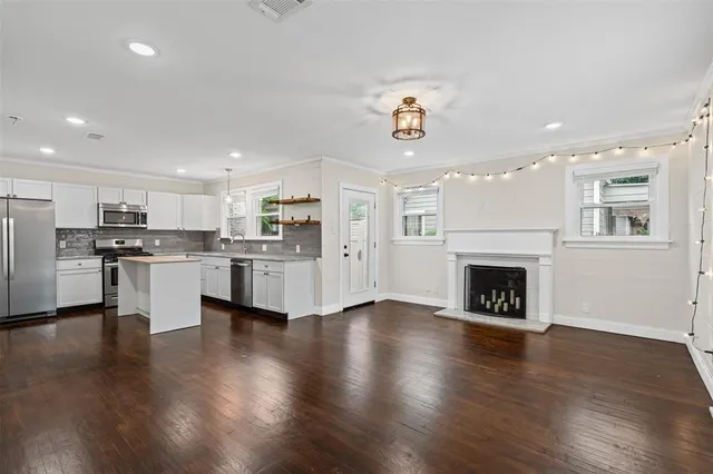 an open kitchen with white cabinets and stainless steel appliances