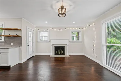 a view of a livingroom with wooden floor a fireplace and window