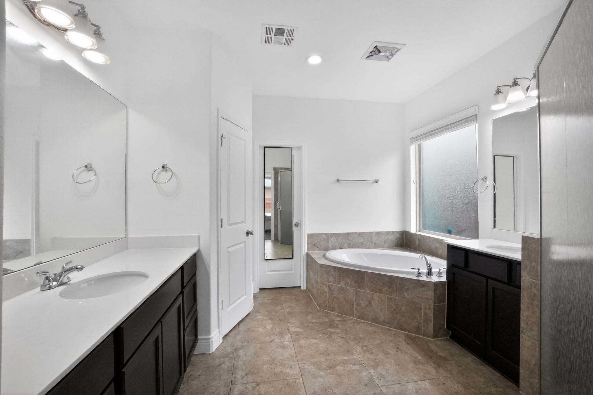 400 Cortona Lane Georgetown, TX 78628 - Photo 20 of 40 Bathroom featuring two vanities, a garden tub, light tile patterned flooring, and recessed lighting