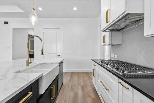 a kitchen with granite countertop a sink stove and cabinets