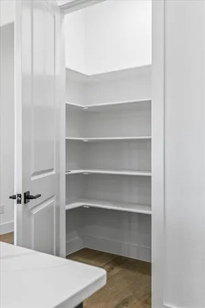a view of walk in closet with empty racks