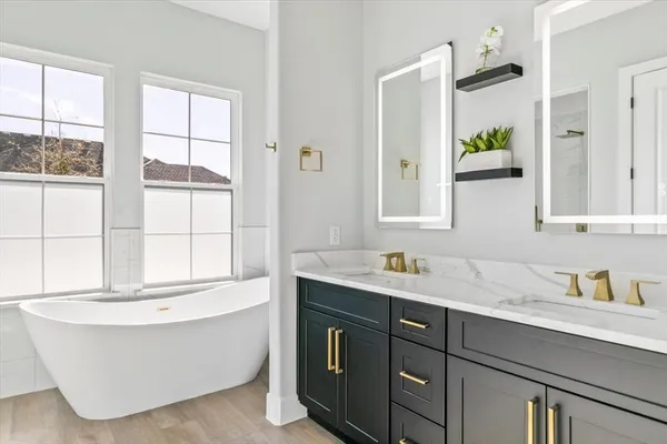 a bathroom with a tub sink and mirror