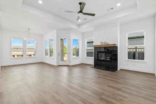 a view of empty room with fireplace and wooden floor