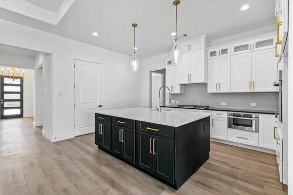 a kitchen with stainless steel appliances granite countertop a sink a stove and a refrigerator