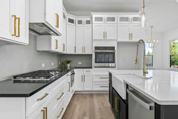 a kitchen with granite countertop a sink stove and cabinets