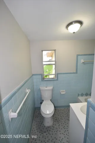 a white toilet sitting next to a bathroom sink and vanity