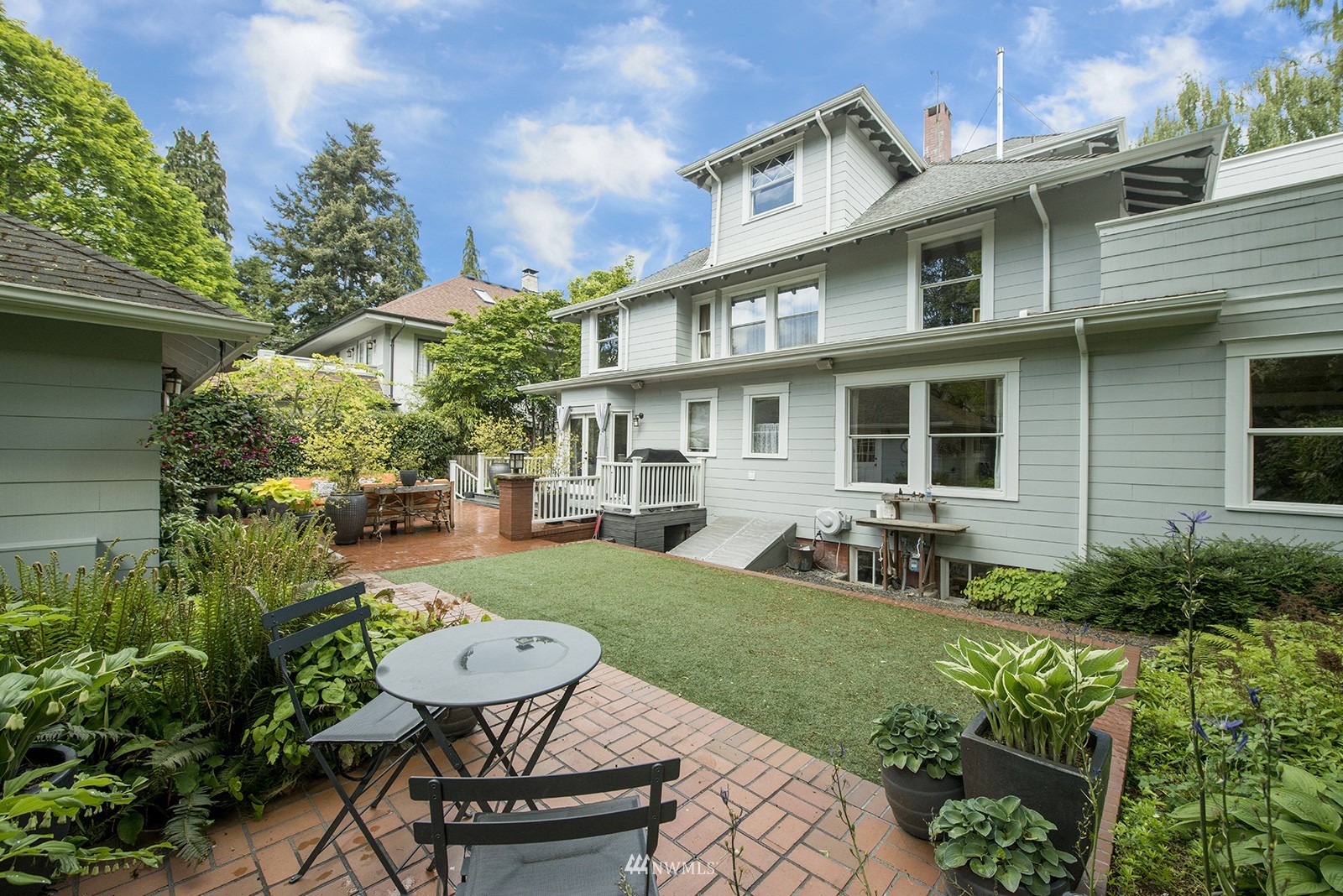 945 17th Avenue East Seattle, WA 98112 - Photo 40 of 40 a view of a patio with table and chairs potted plants and large tree