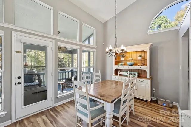 a view of a dining room with furniture a chandelier and wooden floor