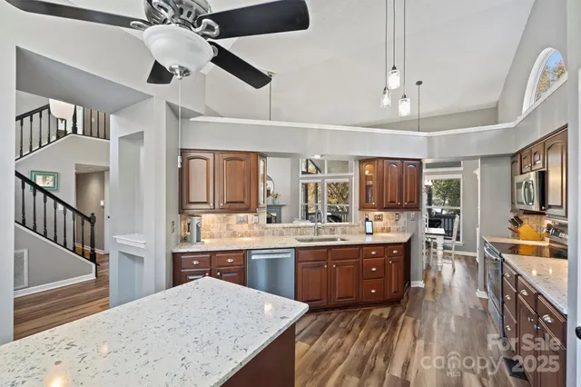a kitchen with stainless steel appliances kitchen island granite countertop a sink and cabinets
