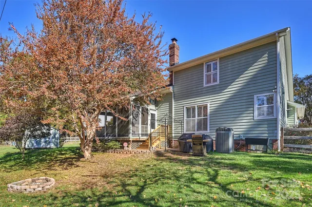 a view of a house with a big yard and large trees