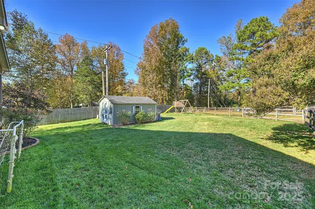 a view of a house with a backyard and a tree