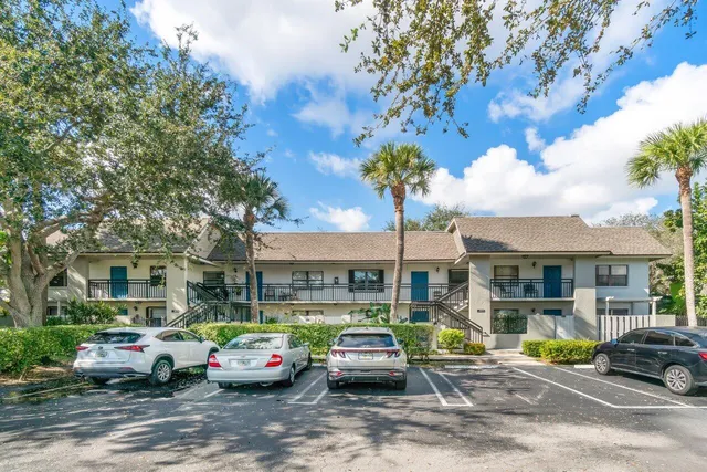 a front view of a building with parked cars