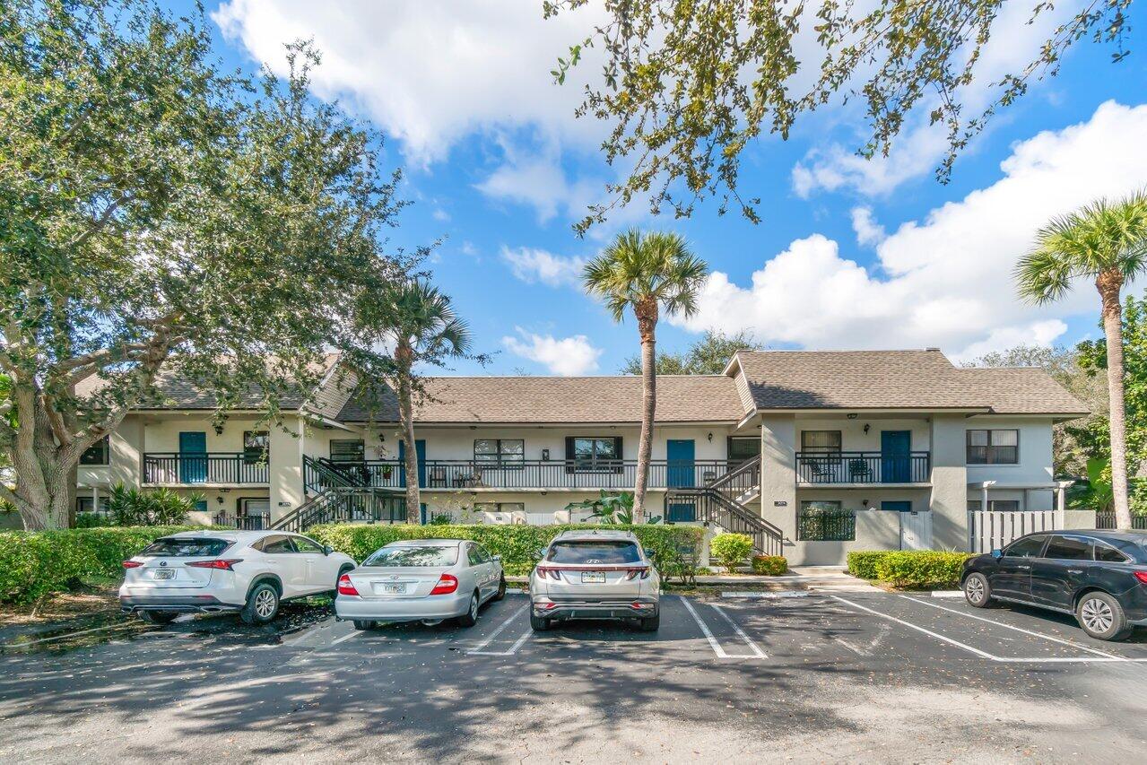 a front view of a building with parked cars